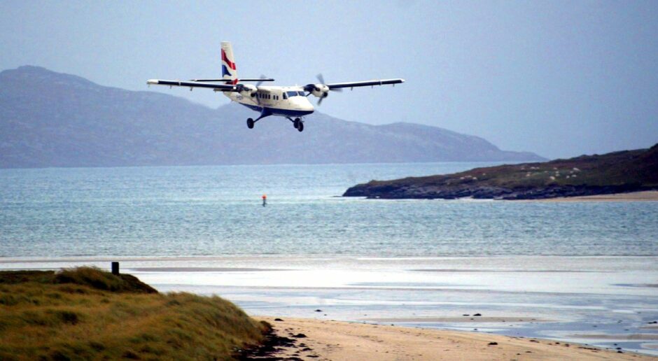 A small plane landing on a beach.