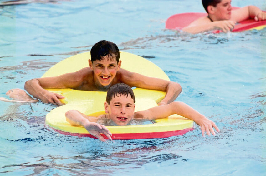 Alan and Kenneth, both 14, enjoy a swim during the school holidays