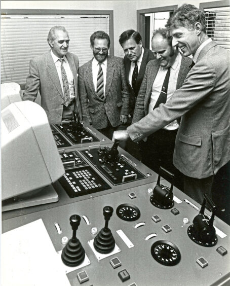 Five men gathered around equipment at Aberdeen Technical College