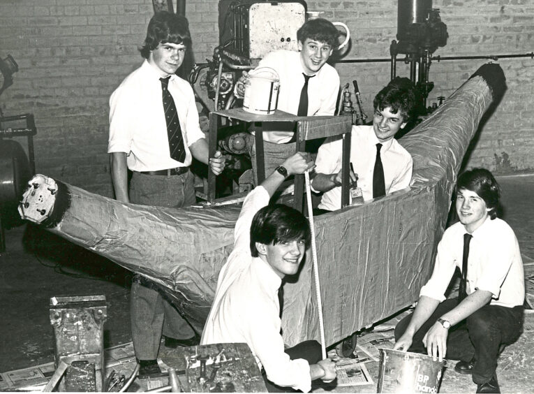 A group of five boys building a banana boat