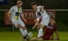 Jamie Michie, left, and Jay Halliday, centre, of Inverurie Locos battle with Rhys Thomas of Keith for possession