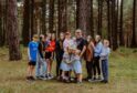 The Sullivan family standing together with woods behind them