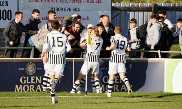 Kane Hester in between the supporters and his team-mates celebrating his third goal against Annan Athletic. Image: Robert  Crombie