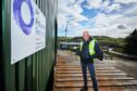 Owner of Pi Polymer Recycling proudly poses in front of his enterprise