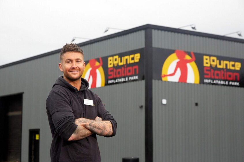 Owner of Bounce Station proudly poses in front of his inflatable park