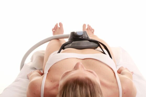 woman lying down while getting Emsculpt NEO treatment
