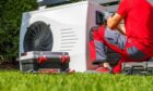 technician installs one of many heat pumps in Scotland