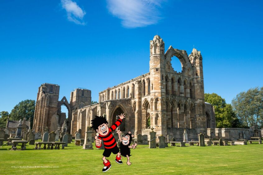 Dennis and Gnasher jump in front of Elgin Cathedral