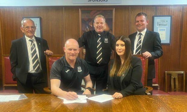 Elgin City manager Gavin Price puts pen to paper on his contact extension. Image: Elgin City FC