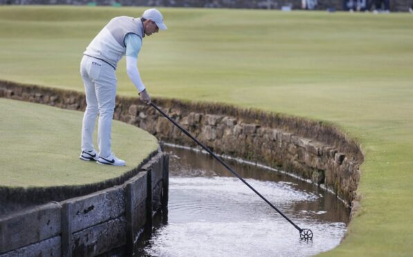 Rory McIlroy hit into the Swilcan Burn on the first but rebounded for a six-under 66.