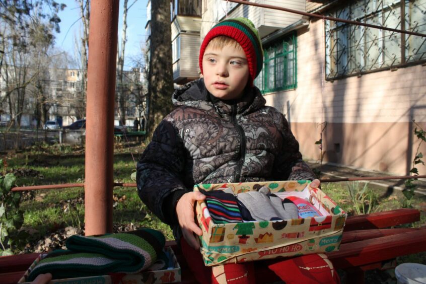 Little kid receiving a Christmas shoebox