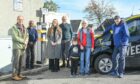 The ribbon-cutting of the new electric vehicle charging point in Culbokie. From left to right:  Bruce Morrison of Ferintosh Community Council, Rasar Rasathurai from the Spar Shop, Becca Purvis from Hitrans, Paul Wadge, volunteer and driver, Janet Bird with grandson Caleb, and bus driver Tony Jankowski. Photo: Jason Hedges.