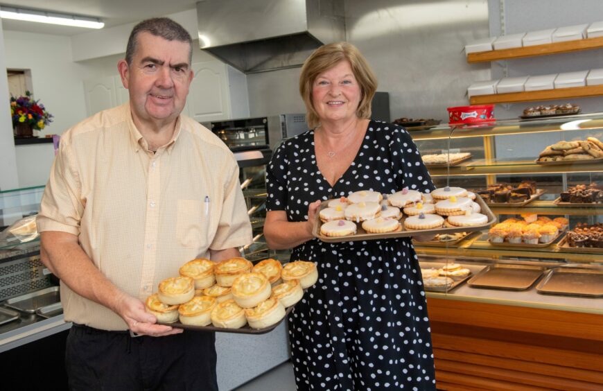 Linda and Patrick Jackson holding trays of baked goods