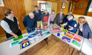 Members of the flag judging panel discuss some of their top designs. Image: Kami Thomson/DC Thomson