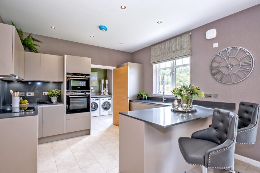 The kitchen with breakfast bar at Lochside of Leys showhome