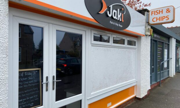Jaki's Chip Shop in Muir of Ord with the new management sign in the window.