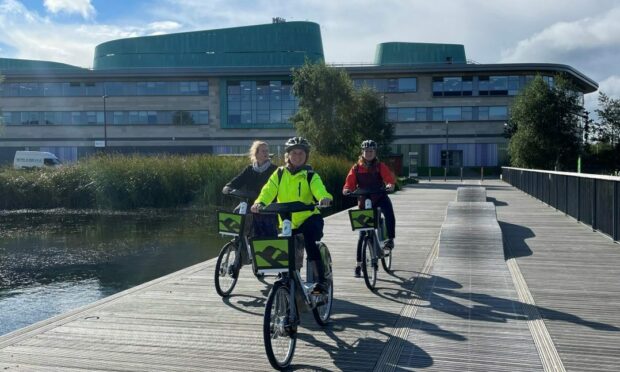 Some of the Hi-Bikes in action earlier this year. Vikki Trelfer, centre, Active Travel Officer at Hitrans, with friends at UHI Campus on the HI-BIKE rentable e-bikes in Inverness. Image: Hitrans.