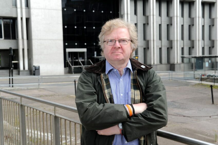 Councillor Ian Yuill standing with his arms folded in front of Broad Street.