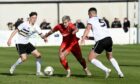 Brora's Jordan MacRae, centre, tries to evade Gary Warren, right and Robbie Thompson of Clach in the North of Scotland Cup fina;