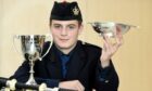 Arran Green of Cowie, Stirlingshire with the Lightning Electrical Cup and the Roderick Munro Memorial Quaich he won in the Strathspey and Reel and March piping competitions. Image: Sandy McCook/ DC Thomson.