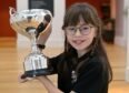Hannah Greig of Salen, Mull with the Cowal Trophy for poetry recitation in the P6-7 category in the Perth Theatre. Image: Sandy McCook/DC Thomson.