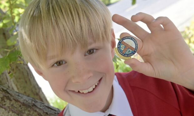 Calum Michael Morrison with his gold badge in the primary seven fluent singing category. Image: Sandy McCook/ DC Thomson.