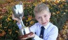 Magnus Montgomery of Back, Lewis with the Alasdair Macinnes Memorial Cup for storytelling in the five to eight age category. Image: Sandy McCook/ DC Thomson.