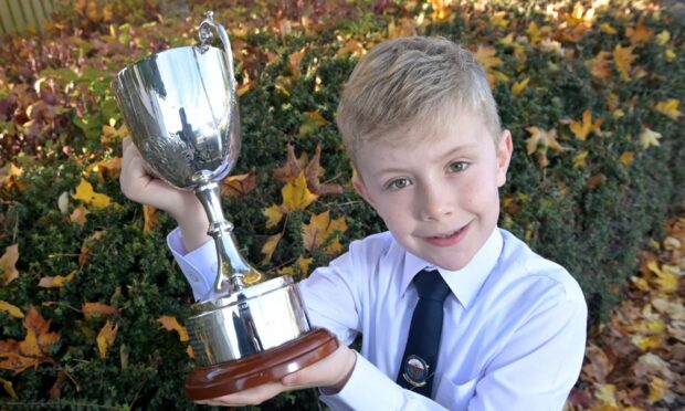 Magnus Montgomery of Back, Lewis with the Alasdair Macinnes Memorial Cup for storytelling in the five to eight age category. Image: Sandy McCook/ DC Thomson.