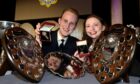 Gold Medal winners Ruairidh Gray of South Uist and Annie MacDonald of Staffin, Skye with their medals and associated trophies from the competition. Image: Sandy McCook/ DC Thomson.