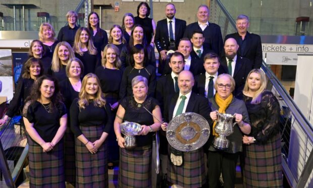 Ronald Murray, conductor of the Lochs Gaelic Choir with the Lorn Shield while other members of the choir hold their extensive collection of silverware. Image: Sandy McCook/ DC Thomson.