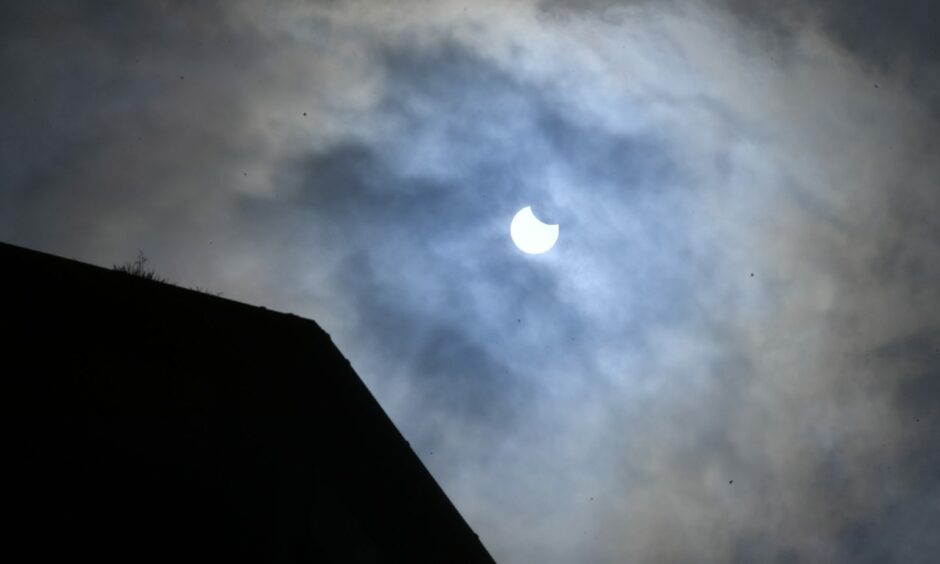 Partial solar eclipse above roof in Aberdeen in June 2021