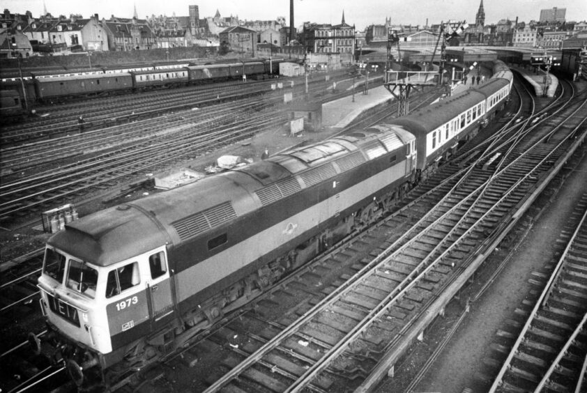 A British Rail diesel locomotive pulls a passenger train out of Aberdeen Joint Station in 1979.