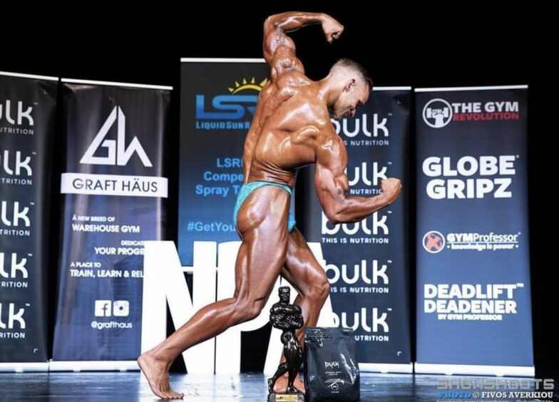 Robert Collie showing muscles in bodybuilding competition 
