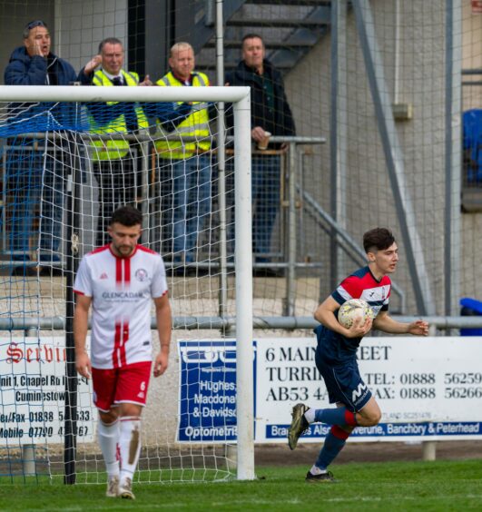 Callan Gray running while holding the ball after scoring