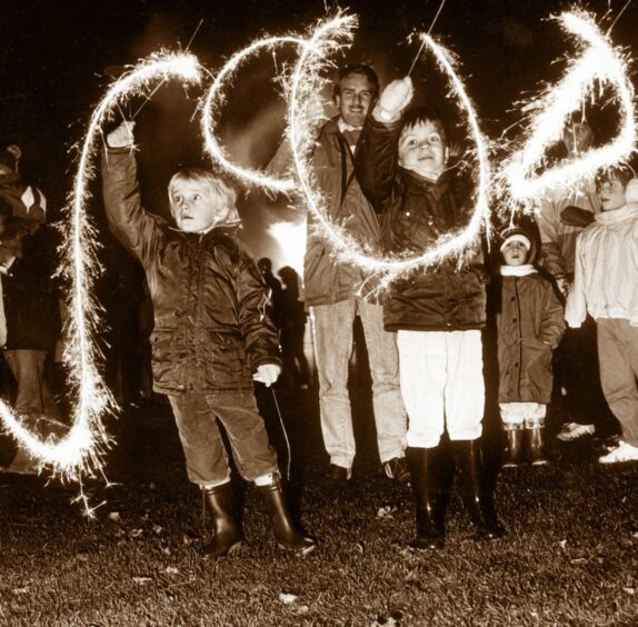 Children drawing in the air with sparklers on Bonfire night Aberdeen 