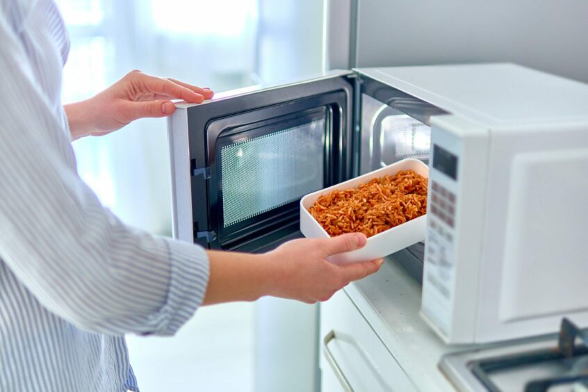 Woman heating up food in the microwave 