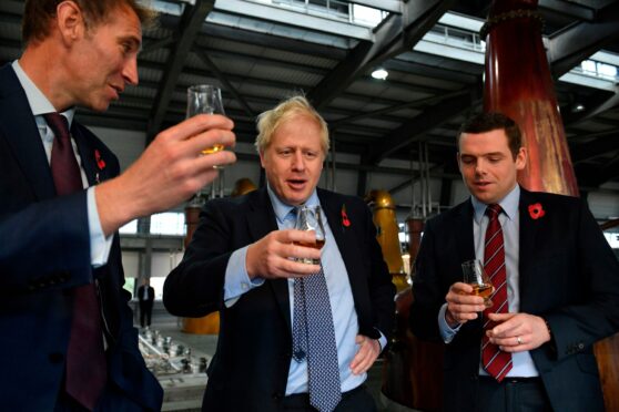Diago global production director Ewan Andrew with former Prime Minister Boris Johnson and Douglas Ross MP at Diageo's Roseisle Distillery where they are standing together drinking whisky. Photo by Daniel Leal-Olivas