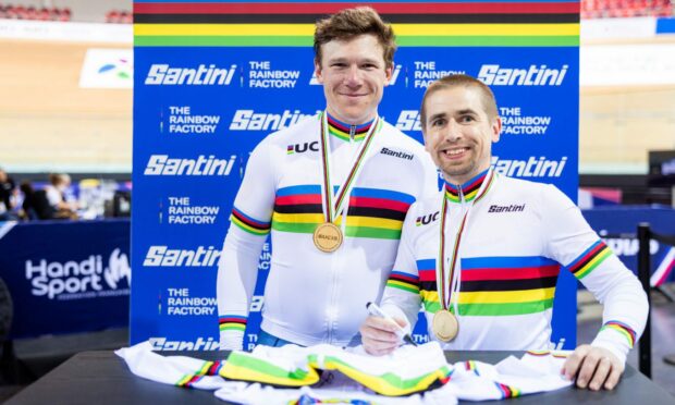 Great Britain's Neil Fachie piloted by Matt Rotherham sign the Santini rainbow jersey after winning gold.