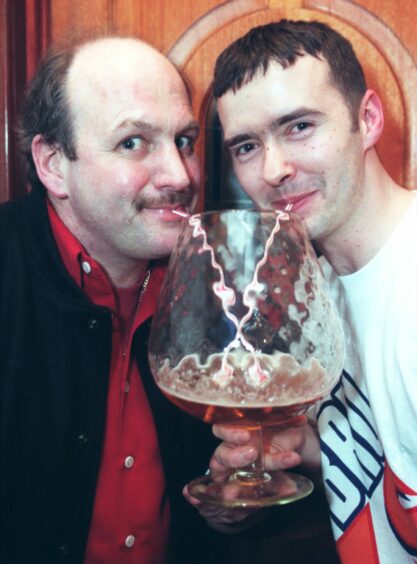 Magnus Slater is pictured left, using a straw to share a drink with his bar manager Kevin Forest.