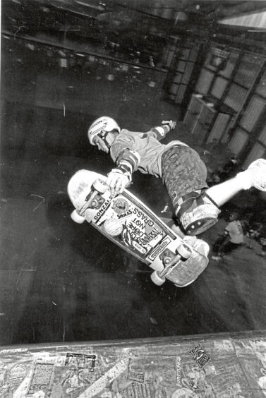 1989 - An action shot of a skateboarder leaping into the dark