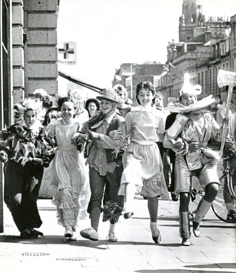 St Margaret's school for girls pupils skipping down Union Street arm-in-arm in costume for their production of the Wizard of Oz.