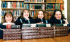 St Margaret's school for girls pupils with their arms resting on piles of books in the library