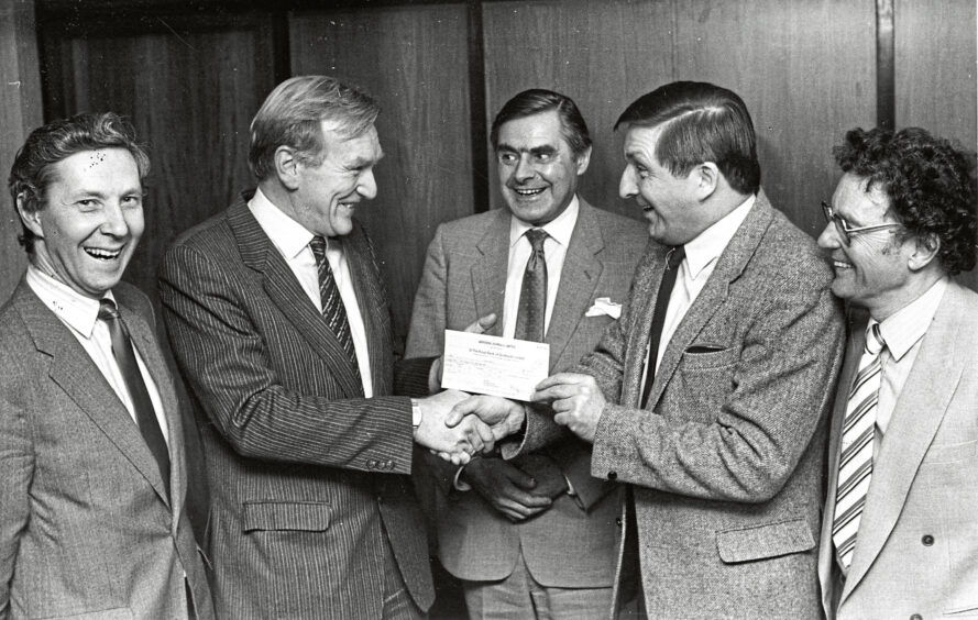 1985 - Evening Express editor Harry Roulston hands over a £600 cheque for the Happy Old Age Appeal to Scotland the What star Buff Hardie.