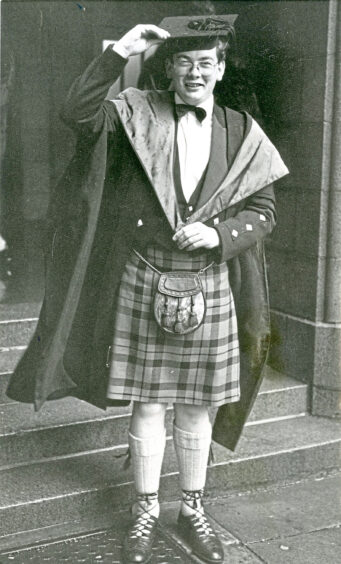 A man in a kilt and graduation robes