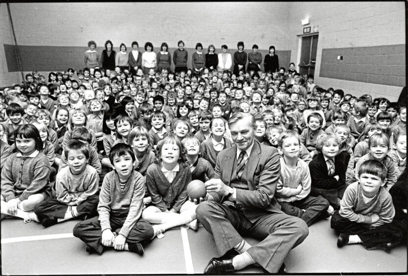 1987 - Royal National Institute for the Blind appeals organiser Stanley Flett with the children of Primary 1 and 2 Glashieburn Primary School after a social education talk.