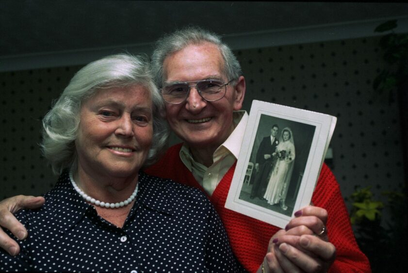 Ilse Collinson and husband Bill shown holding their wedding picture, on the occasion of their 50th wedding anniversary.