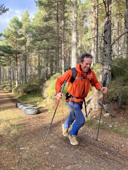 Ben Weber walking up hill in Highland forest to prepare for his South Pole challenge to raise funds for cancer research in memory of his mum