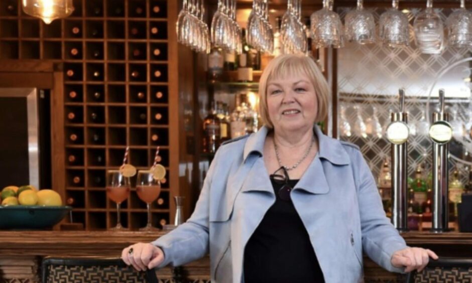 Carol Fowler standing in front of a hotel bar
