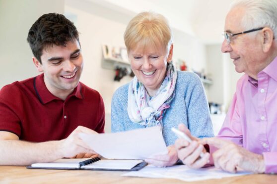 young man helps older couple to prepare their power of attorney and last will and testament