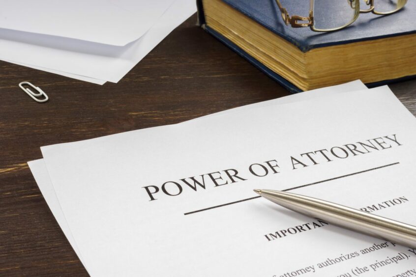 a pen sits on top of a power of attorney on a desk 